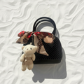 Borsa nera perle con orsetto flat lay